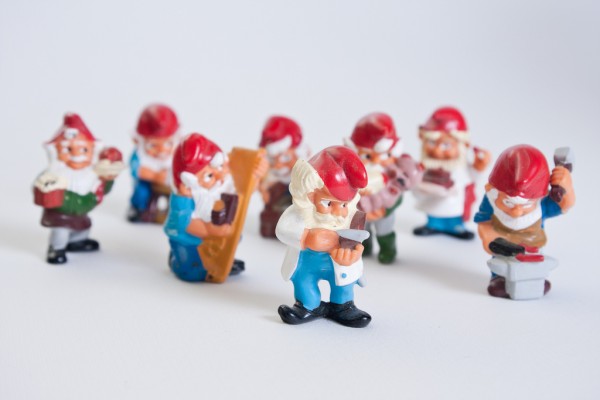 A group of eight Kinder egg working gnomes surprises from the 90's collections, captured against a white background. It includes a barber, a blacksmith, a carpenter, a chef and a few others.